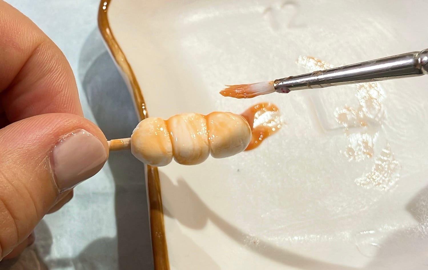 軽量粘土で作った団子に、タミヤのキャラメルソースを塗る様子