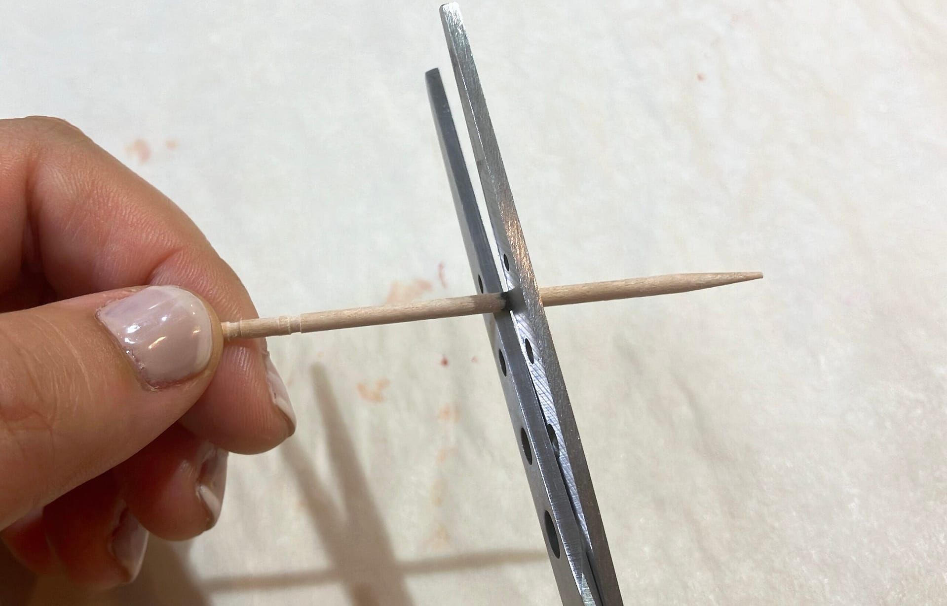 ハサミで爪楊枝に切り跡を付ける様子