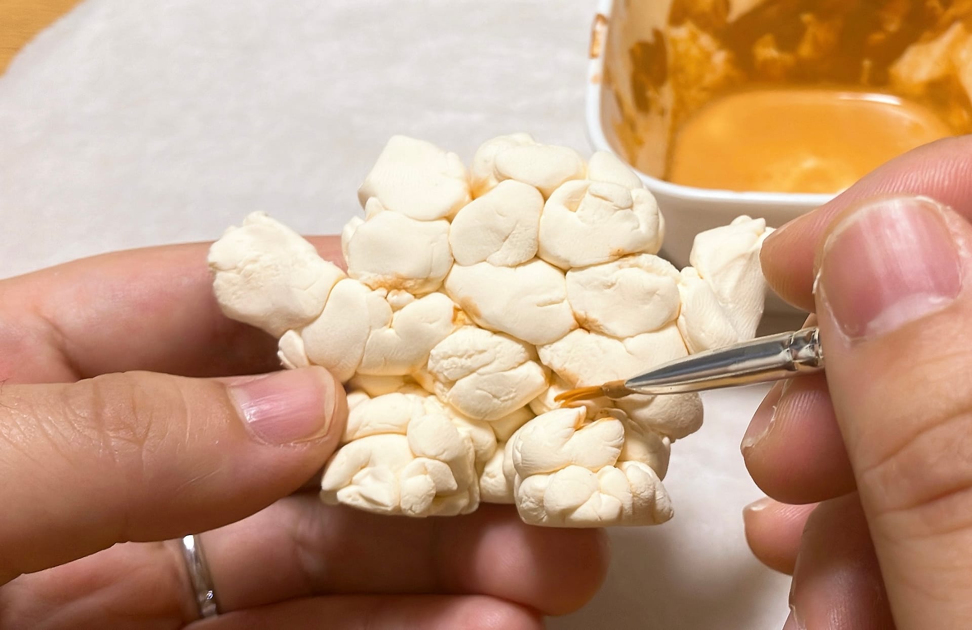 軽量粘土で作ったポップコーン星人に、色を付ける様子