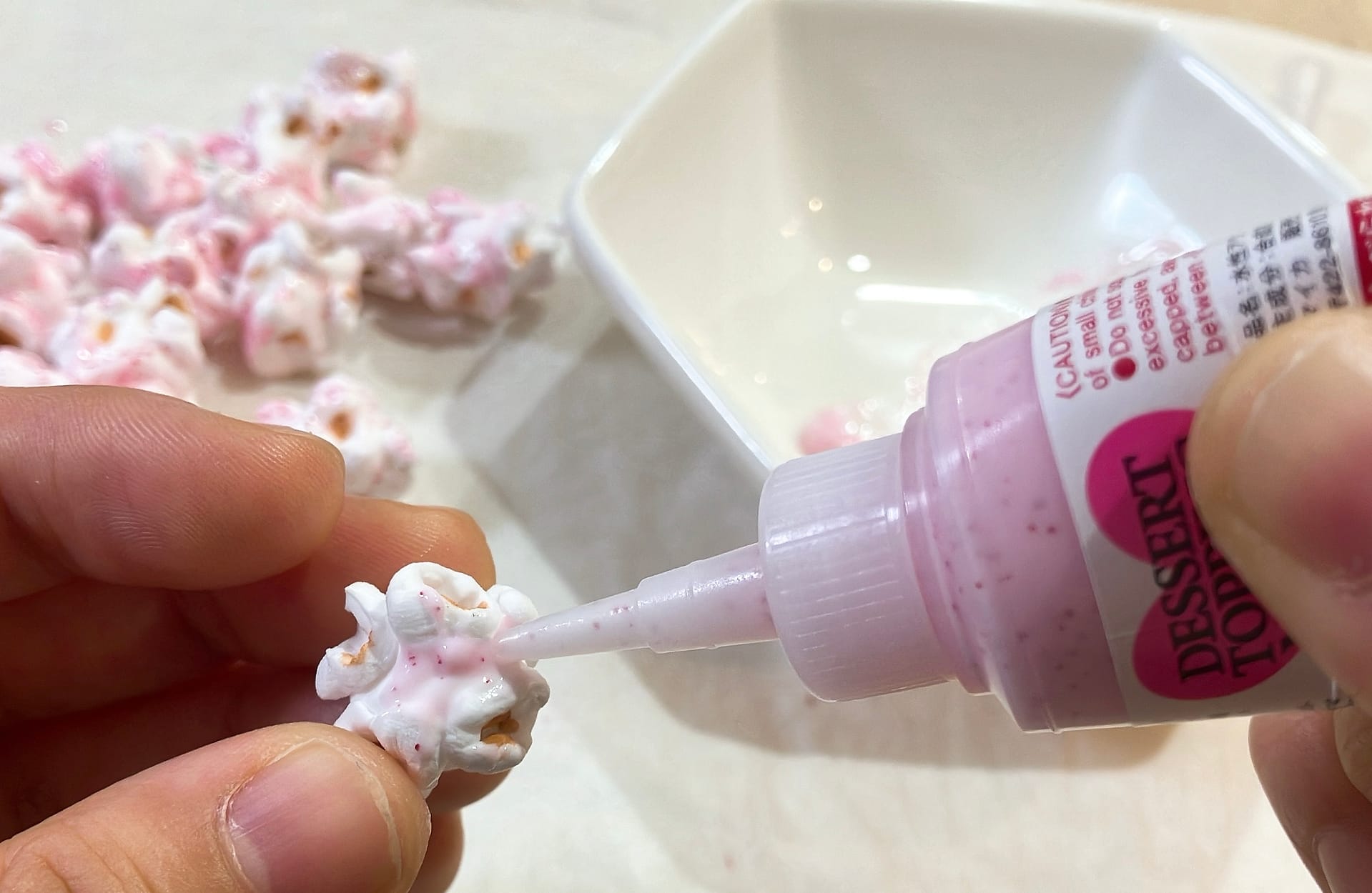 ポップコーンにいちごソースを塗る様子