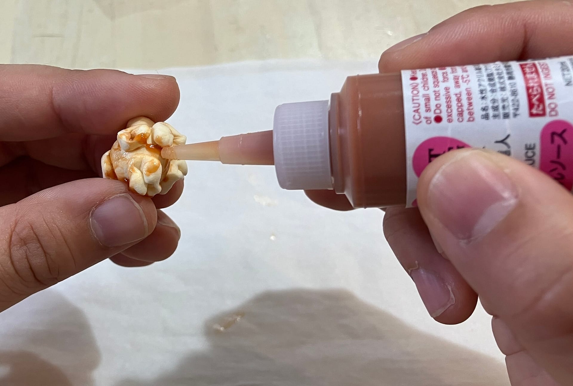 ポップコーンにキャラメルソースを塗る様子の解説図