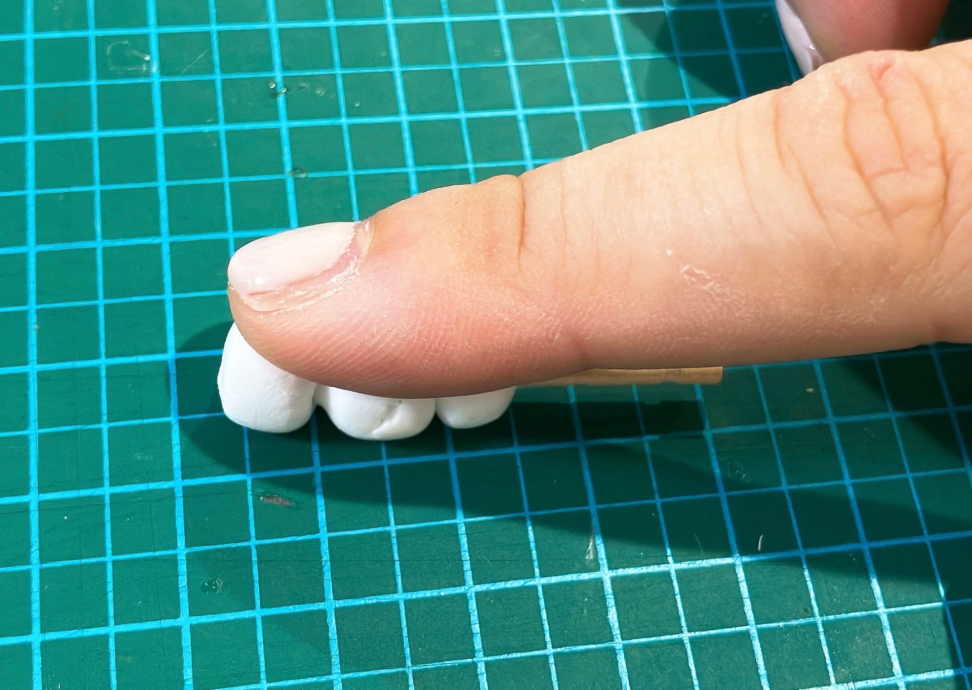 軽量粘土で作った団子を平らにする様子